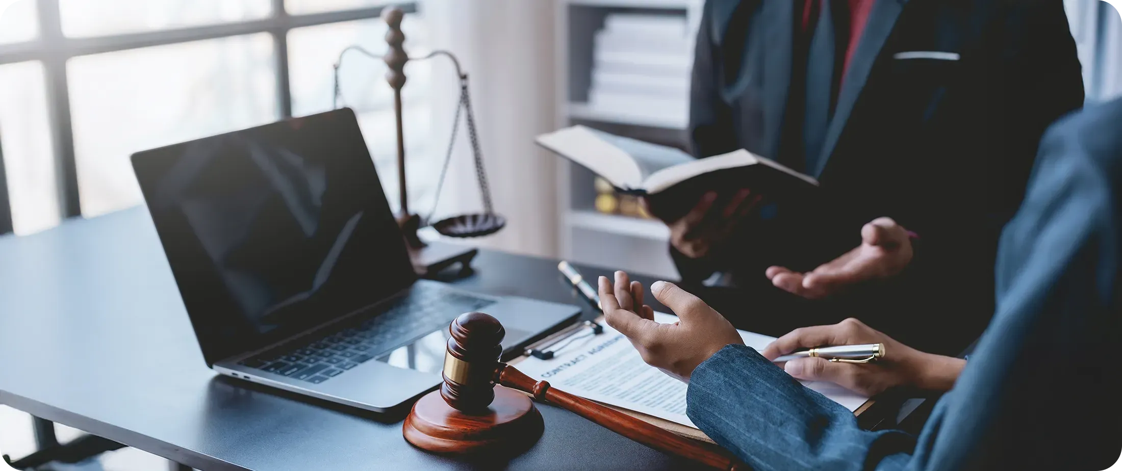 Lawyers reviewing legal documents beside a laptop, symbolizing AI verification, legal analysis, and reducing hallucination risk in legal workflows