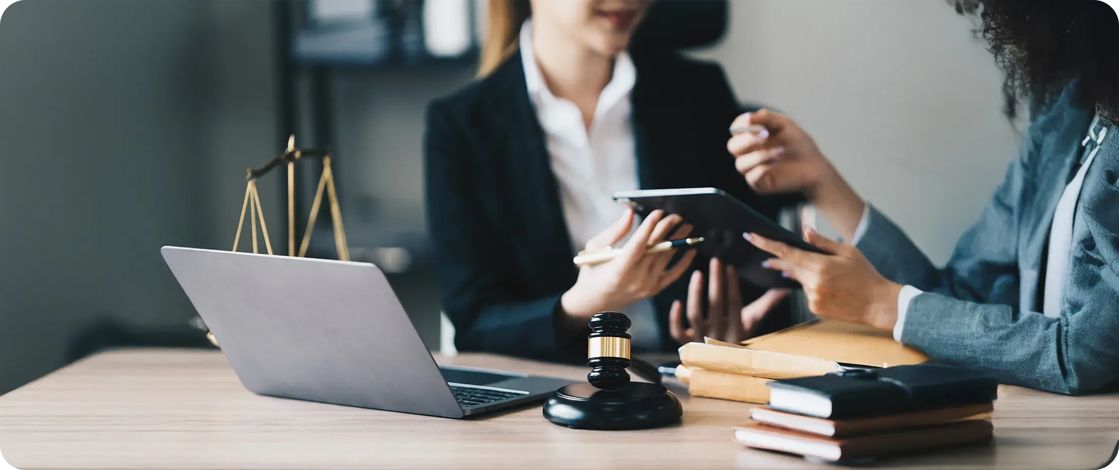 Legal professionals reviewing documents on a tablet and laptop, illustrating collaborative decision-making and responsible handling of client information